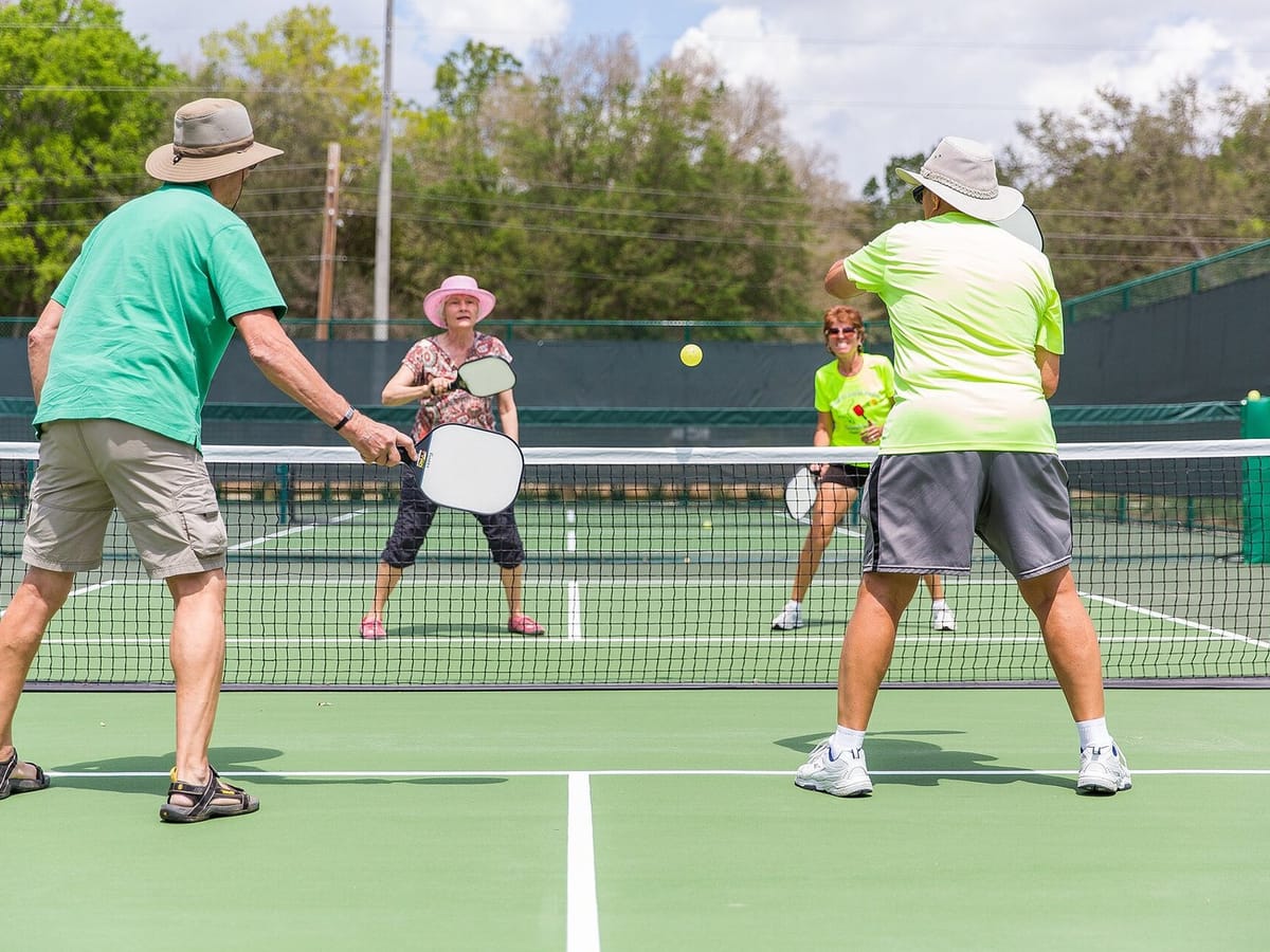 A group of players at an open play session on outdoor courts