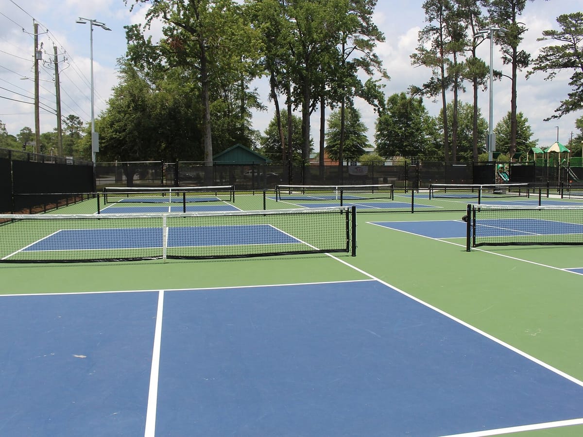 A pickleball court with the net and the non-volley zone line